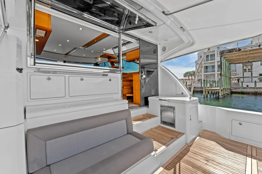 Yacht aft deck seating with open galley window at the dock