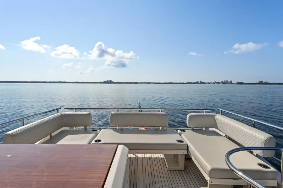 Flybridge lounge seating and teak table overlooking open bay water