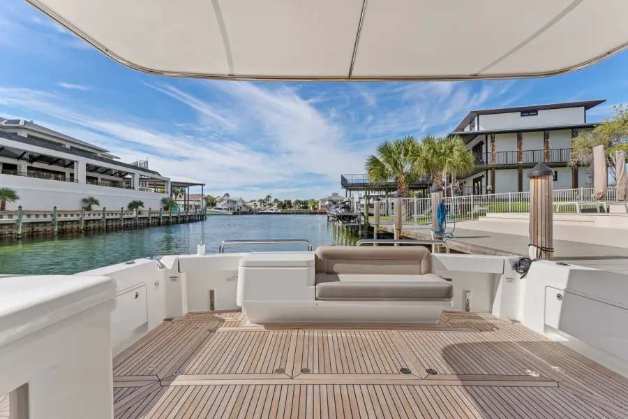 Shaded cockpit with sun pad facing a palm-lined Emerald Coast canal